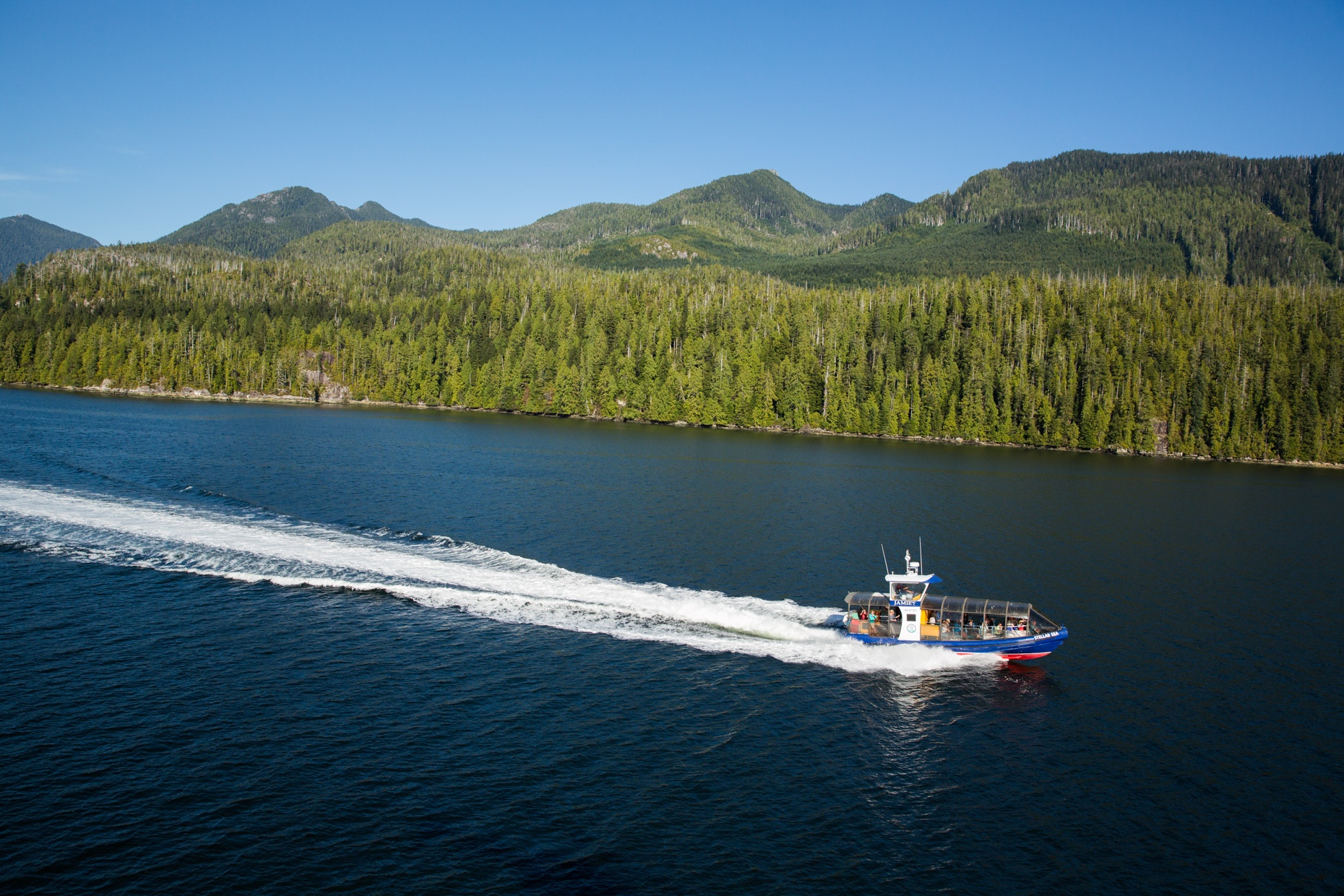 a small boat in a body of water with a mountain in the background