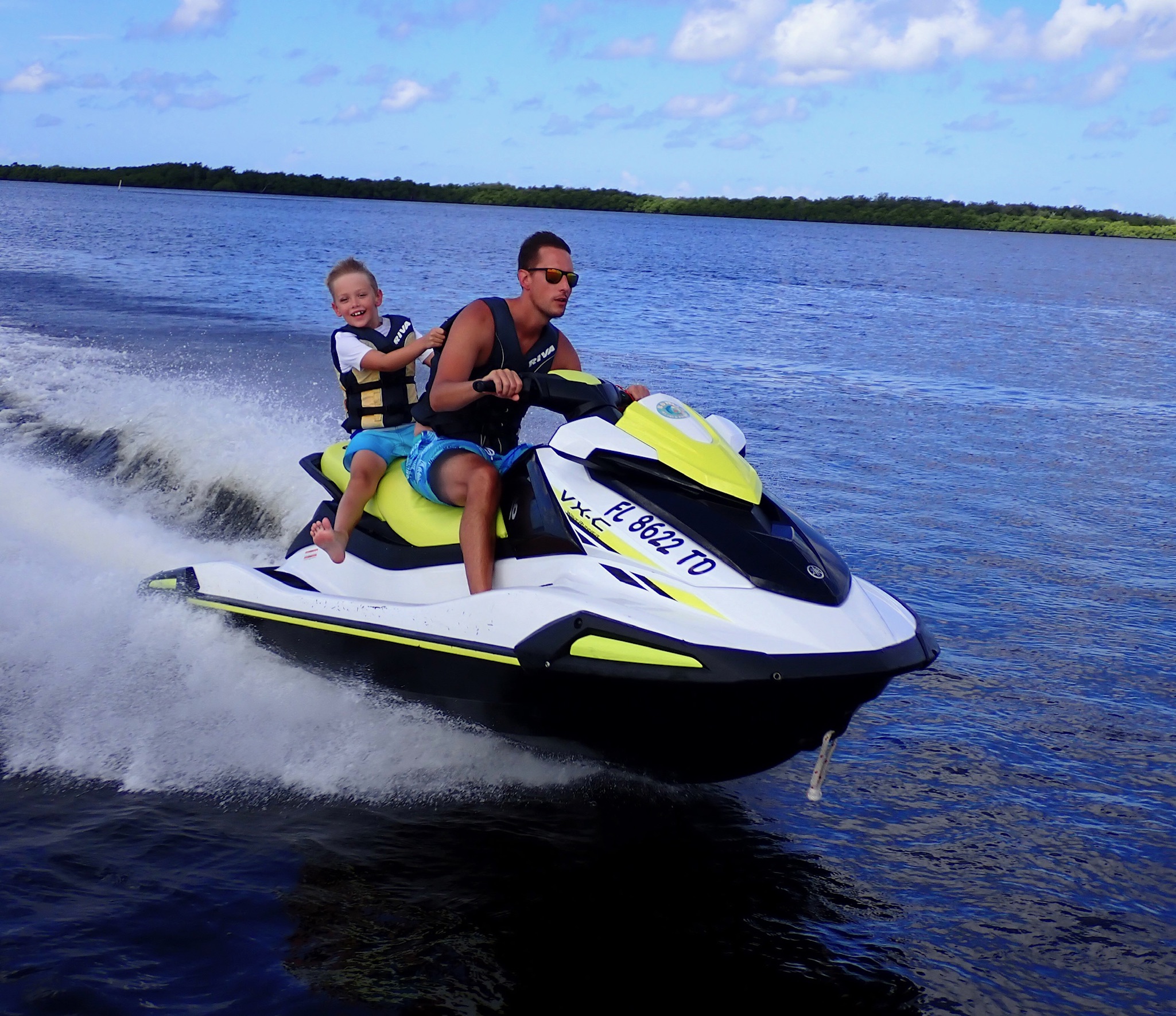 a man riding on the back of a boat on a body of water