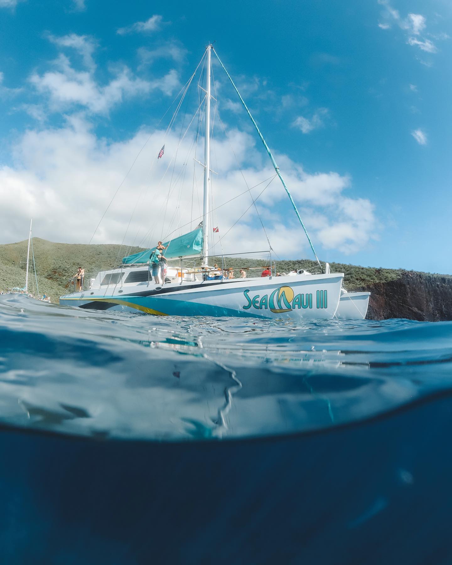 a blue and white boat sitting next to a body of water